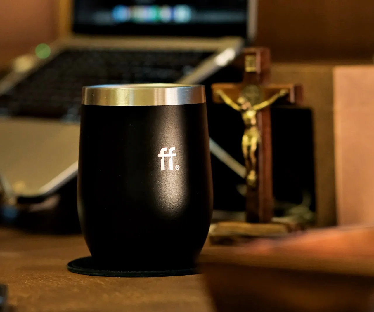 copo de café térmico sobre uma mesa de madeira com a logo da marca arcaffo